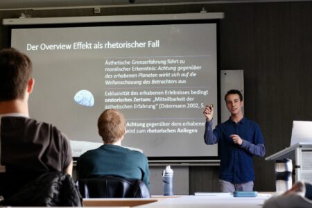 Hagen Wagner präsentiert am 21. April 2023 im Brechtbau seine Bachelorarbeit zum Thema Overview Effekt als rhetorischer Fall